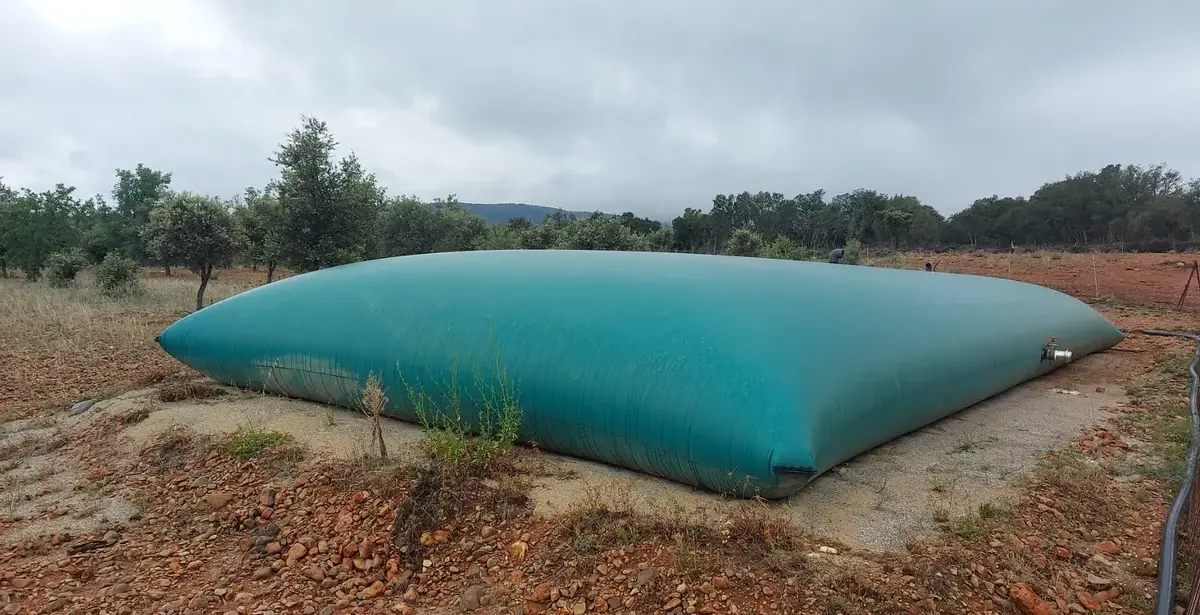 Depósito flexible para agua de riego instalado en una finca de olivos y almendros